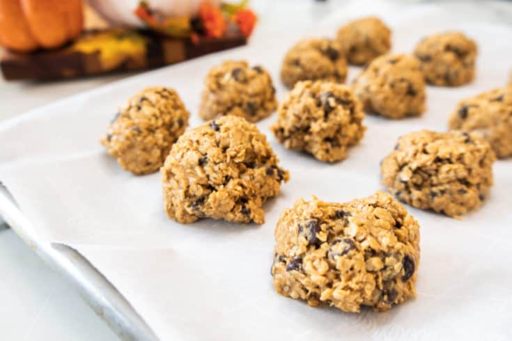 peanut butter oatmeal balls with chocolate chips on parchment paper baking sheet