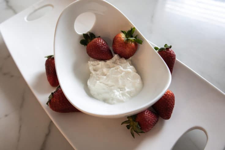 white bowl of yogurt with strawberries