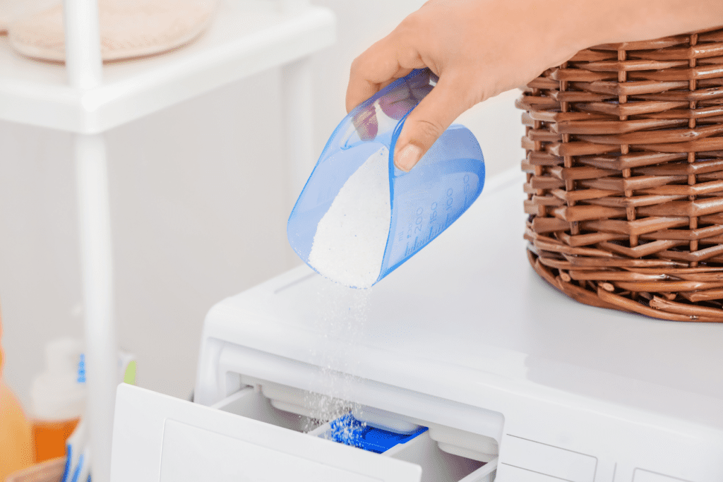 scooping detergent into washer